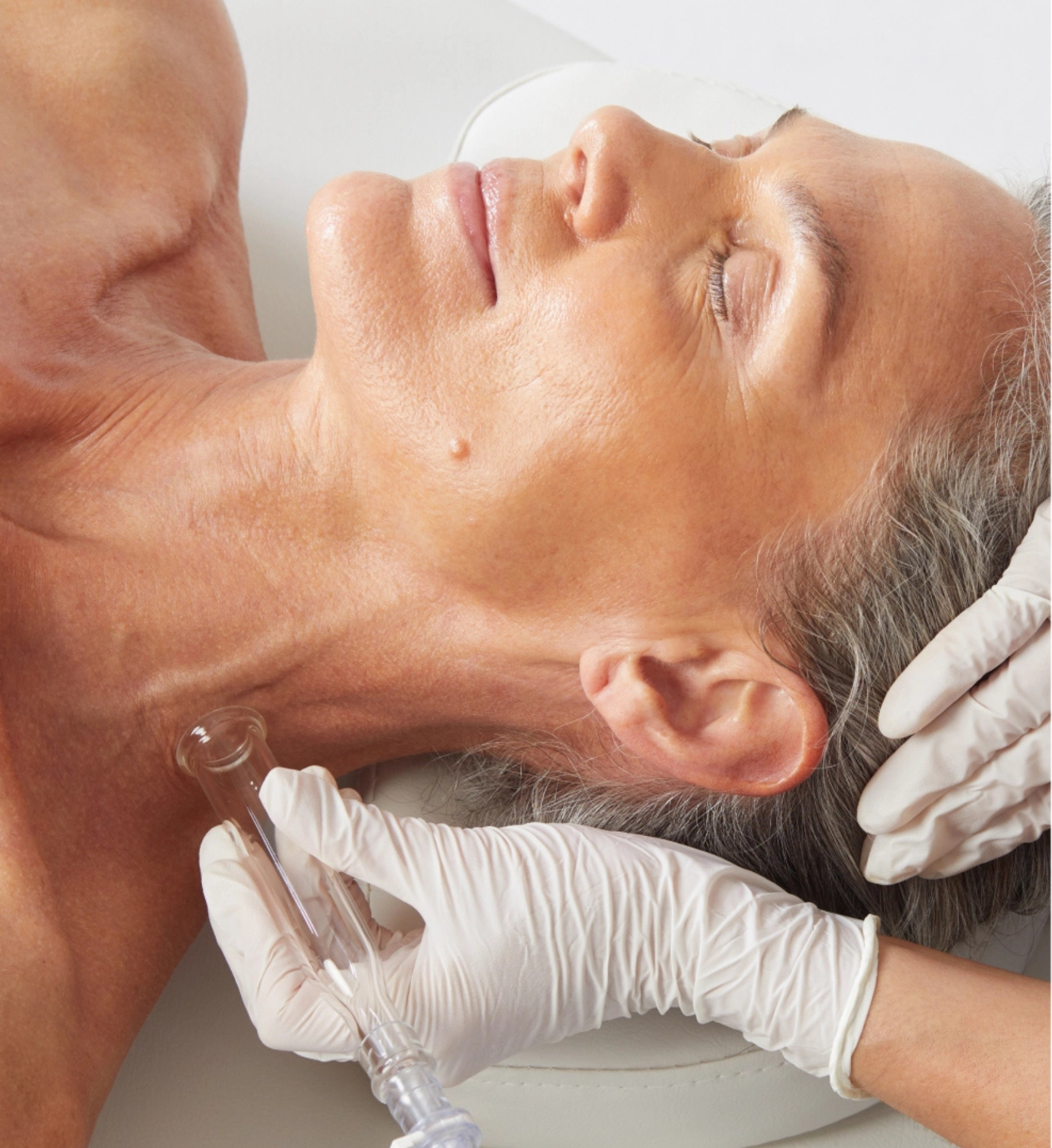 A patient enjoying a relaxing lymphatic drainage massage as part of a Platinum Hydrafacial treatment, designed to detoxify and reduce puffiness.
